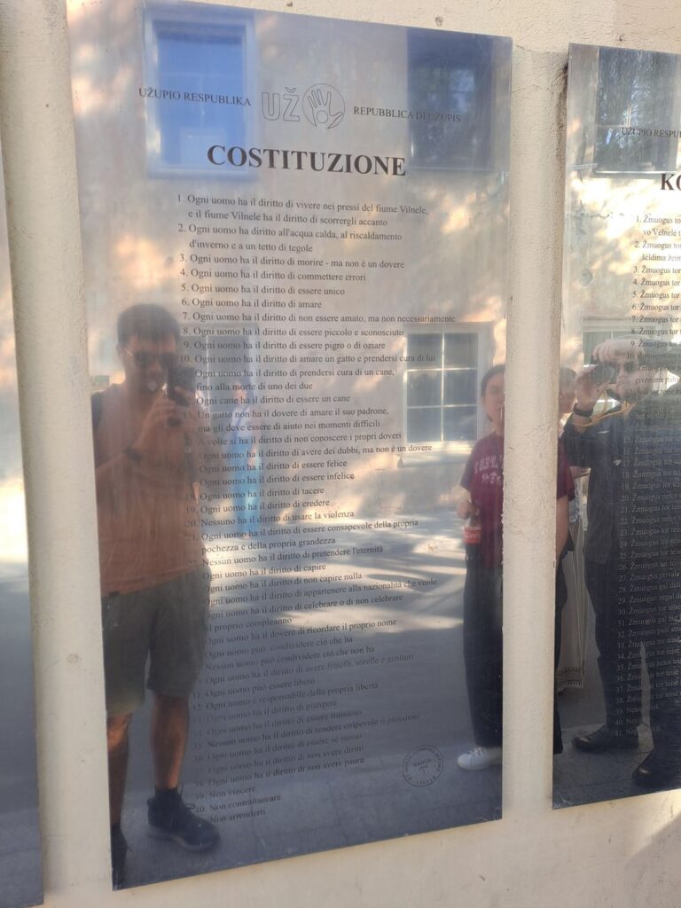 La Costituzione della Repubblica di Užupis in italiano su lastra di metallo lucido a Vilnius