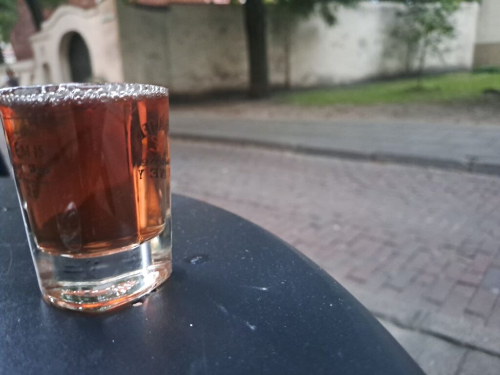 Bicchierino di Suktinis, il nettare di idromele lituano, su un tavolino all'aperto a Vilnius