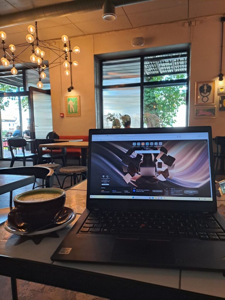 Laptop e cappuccino sul tavolo di un caffè a Telliskivi, quartiere creativo di Tallinn